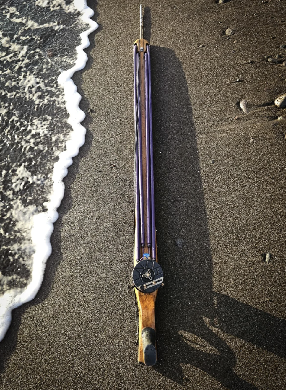 Handcrafted speargun on black sand
